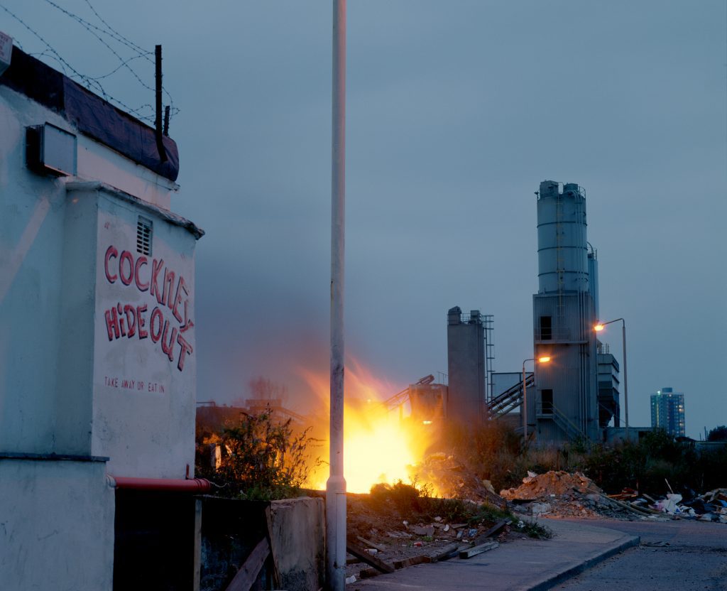 Derelict Cockney Hideout cafe with industrial fire at dusk, Stratford, East London, 1980s, now site of Olympic Park